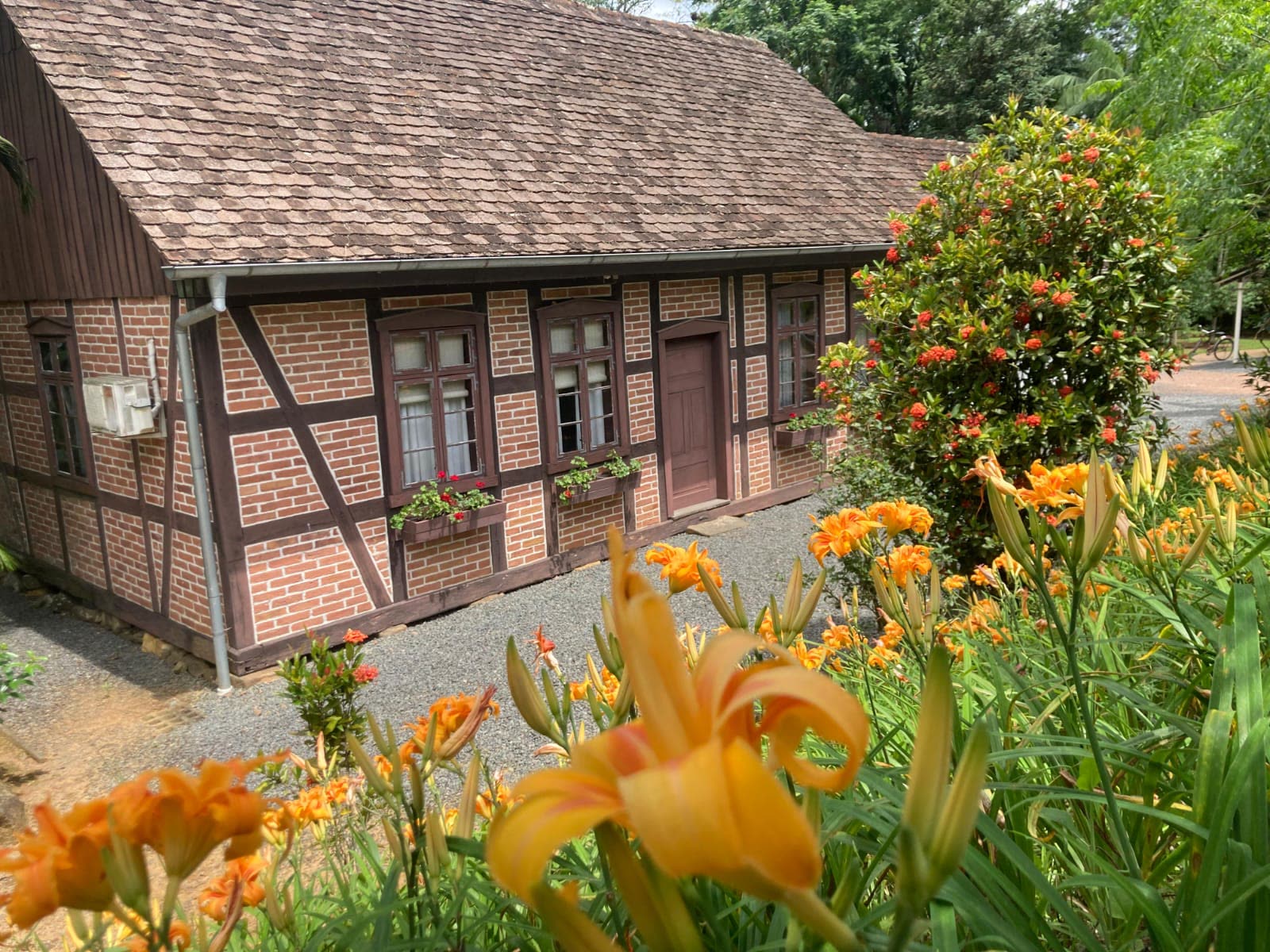 Fachada da Pousada Enxaimel com jardim de lírios